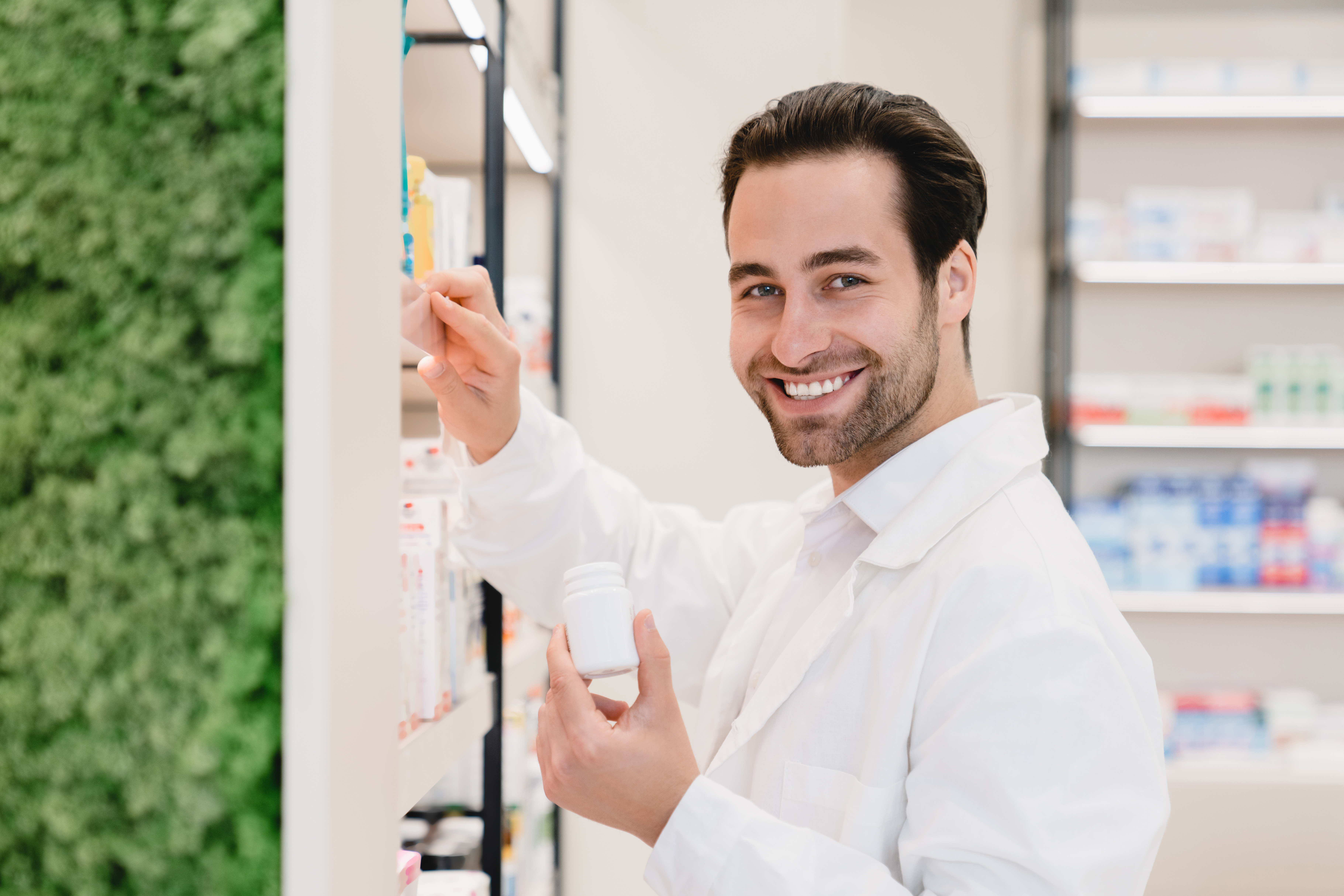 Professional pharmacist examining supplement bottles in modern pharmacy environment